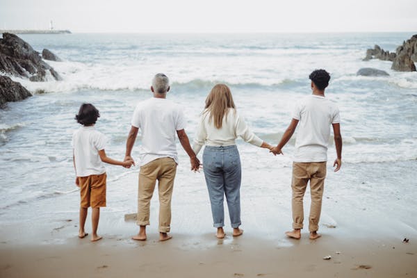 free photo of happy family holding hands at the beach
